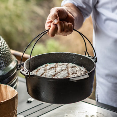 Gusseiserner Dutch Oven mit knusprigem, frisch gebackenem Brot